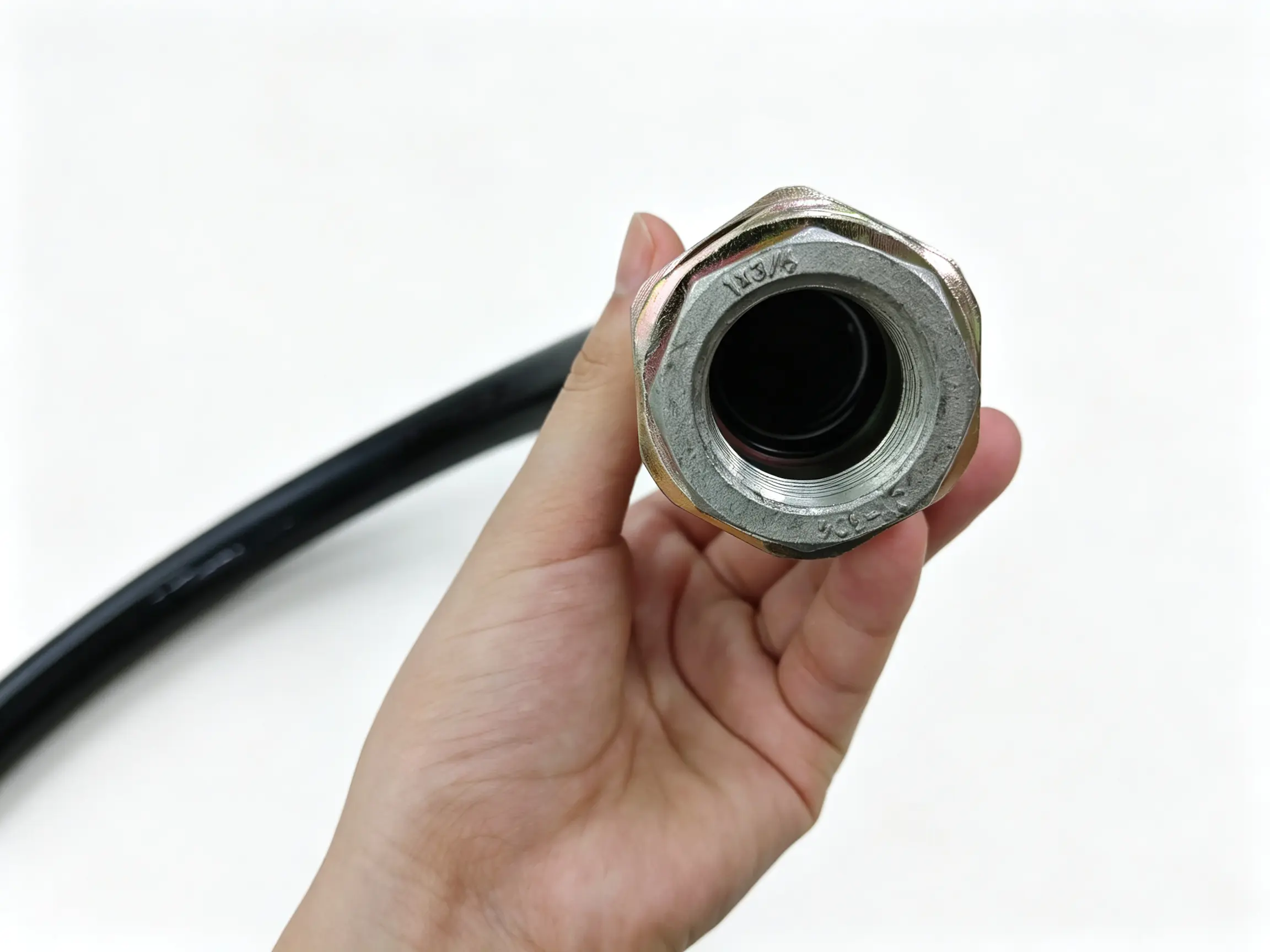Explosion‑Proof Flexible Conduit Threaded Fitting Close‑Up Close‑up of internal threaded metal fitting for explosion‑proof flexible conduit, hand‑held shot showing NPT/BSPP thread port, fuel dispenser explosion protection cable gland accessory